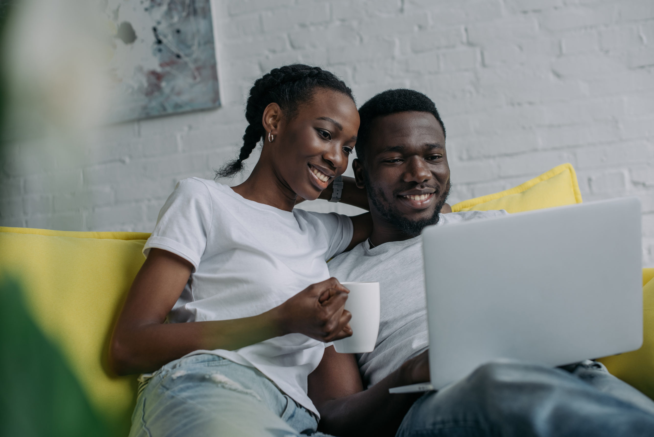 Happy,Young,African,American,Couple,Using,Laptop,Together,At,Home